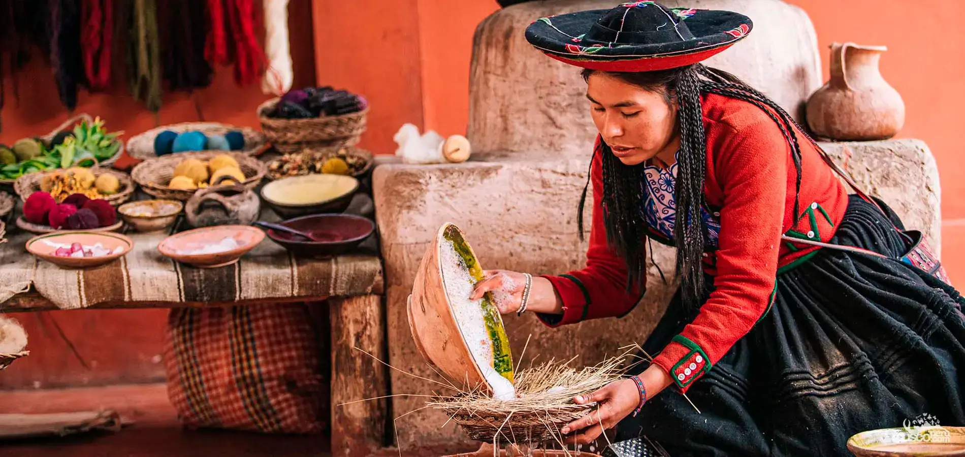 Tejedora de Chinchero moliendo tintes naturales, junto a los cuencos de pigmento y la lana ya teñida