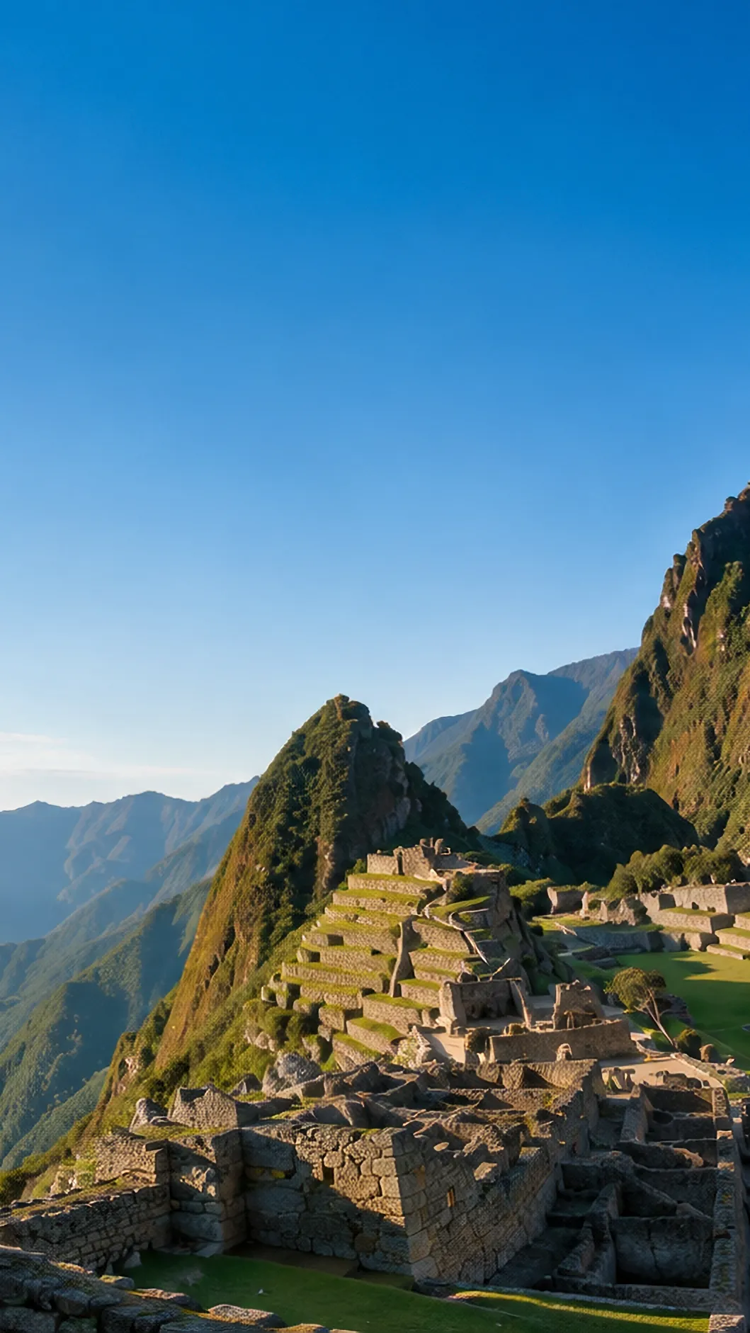 Machu Picchu al amanecer: la ciudadela sobre la terraza alta, con el Huayna Picchu detrás y el valle del Urubamba al fondo